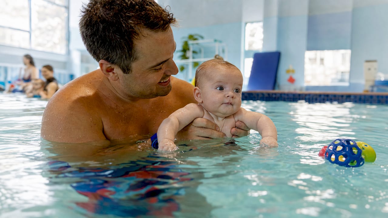 Father bonding with baby in swim class