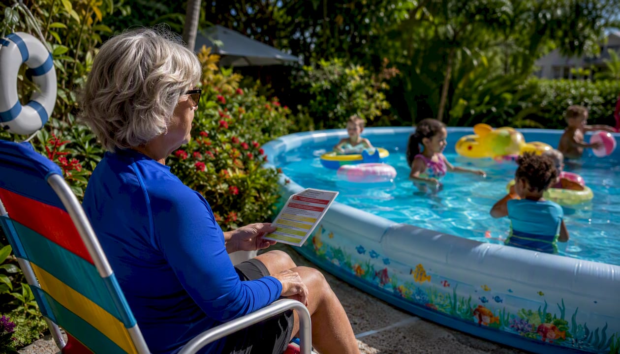 Water watcher supervising children at backyard pool