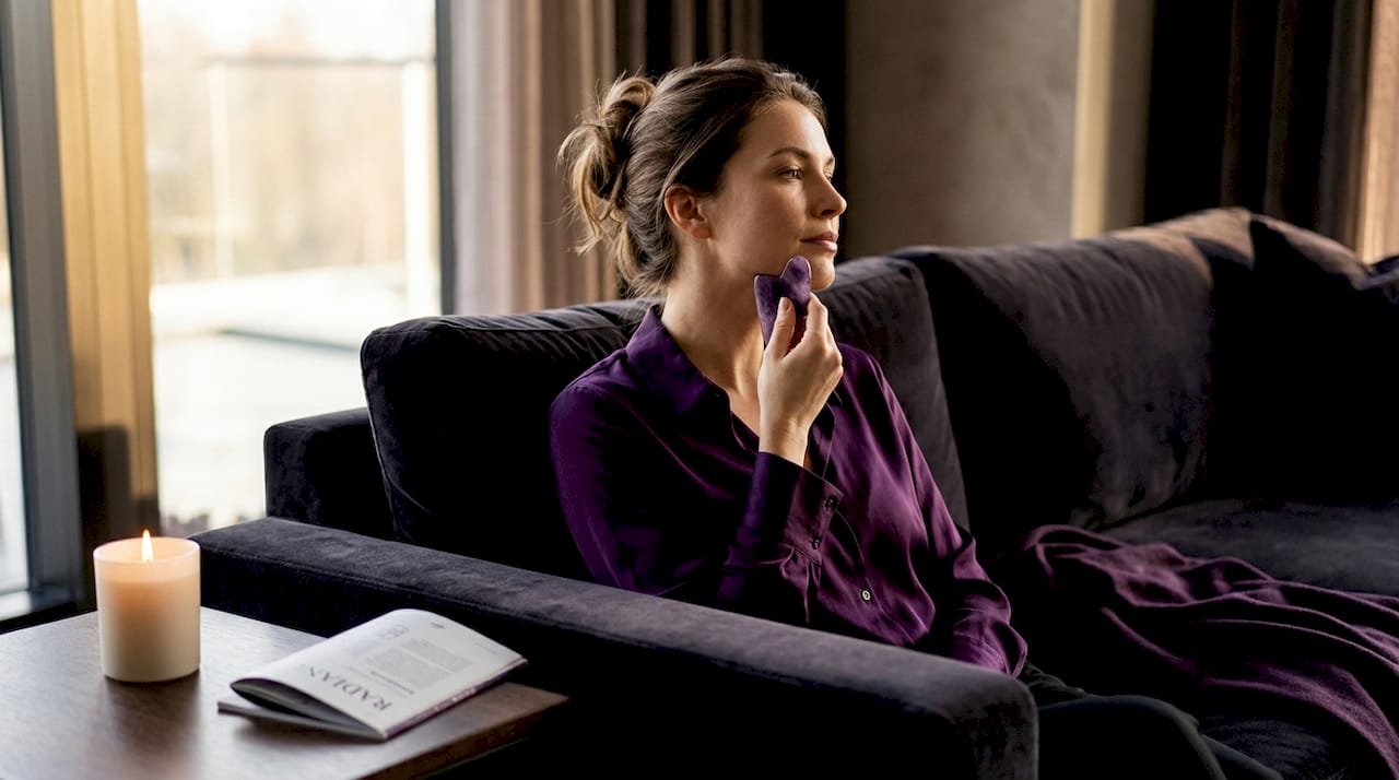 Woman demonstrating gua sha facial technique