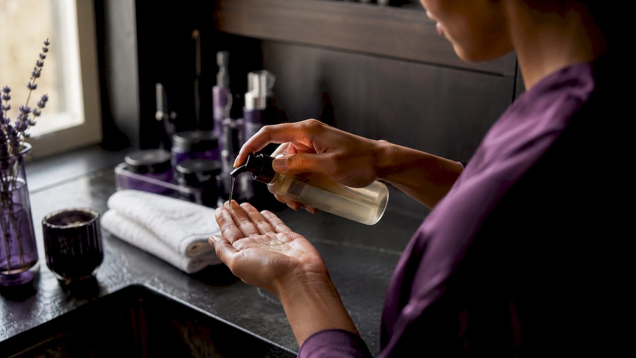 Hands dispensing oil cleanser during double cleansing