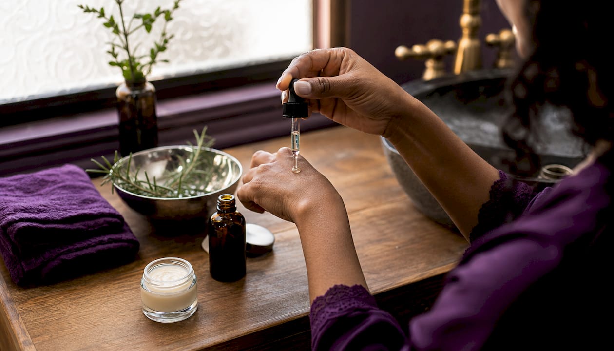 Close-up of hand applying hyaluronic acid serum