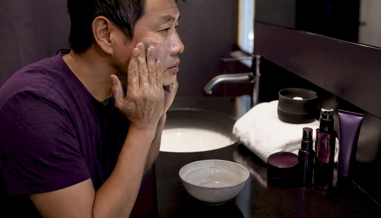 Man massaging oil-based cleanser on face