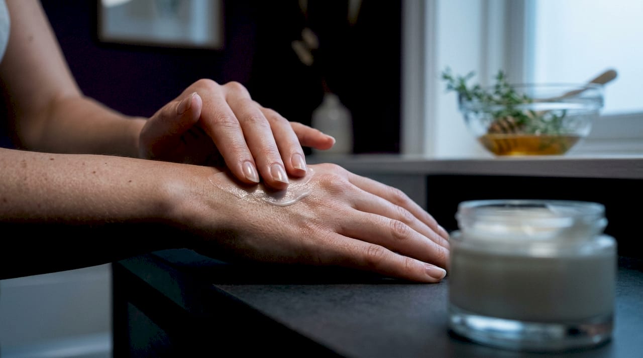 Hands massaging moisturizing cream on skin