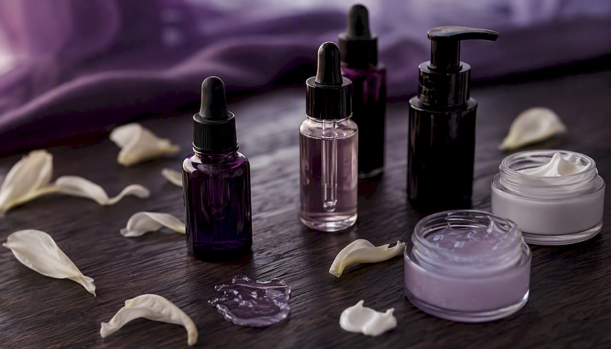 Skincare bottles arranged on black surface