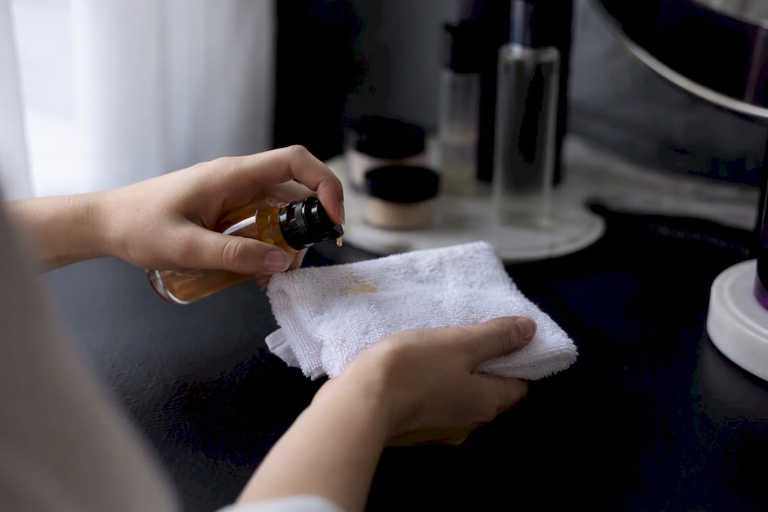 Hands layering serum and ampoule in skincare routine