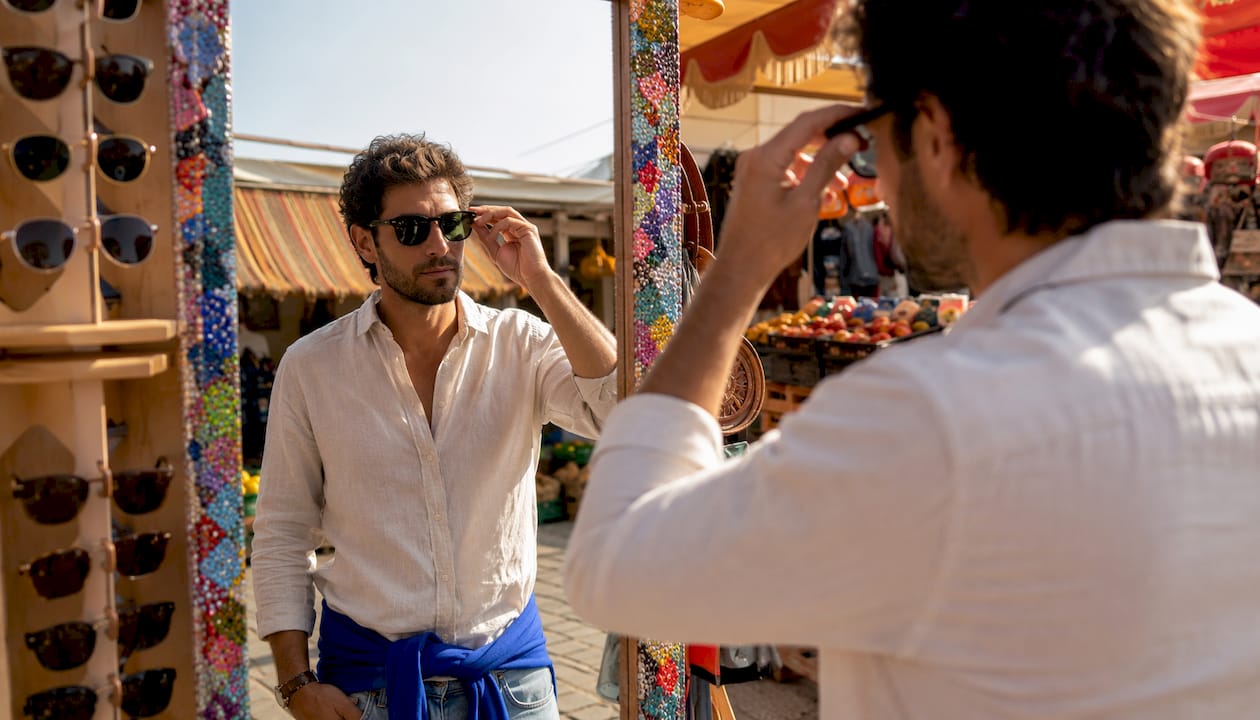 Man choosing Wayfarer sunglasses in boutique