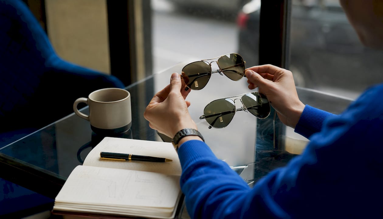 Hands comparing aviator sunglasses frames size