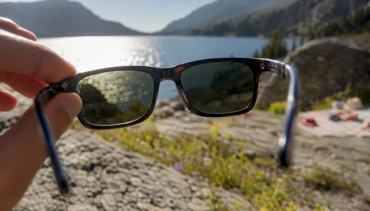 Sunglasses lens reducing glare over lake water