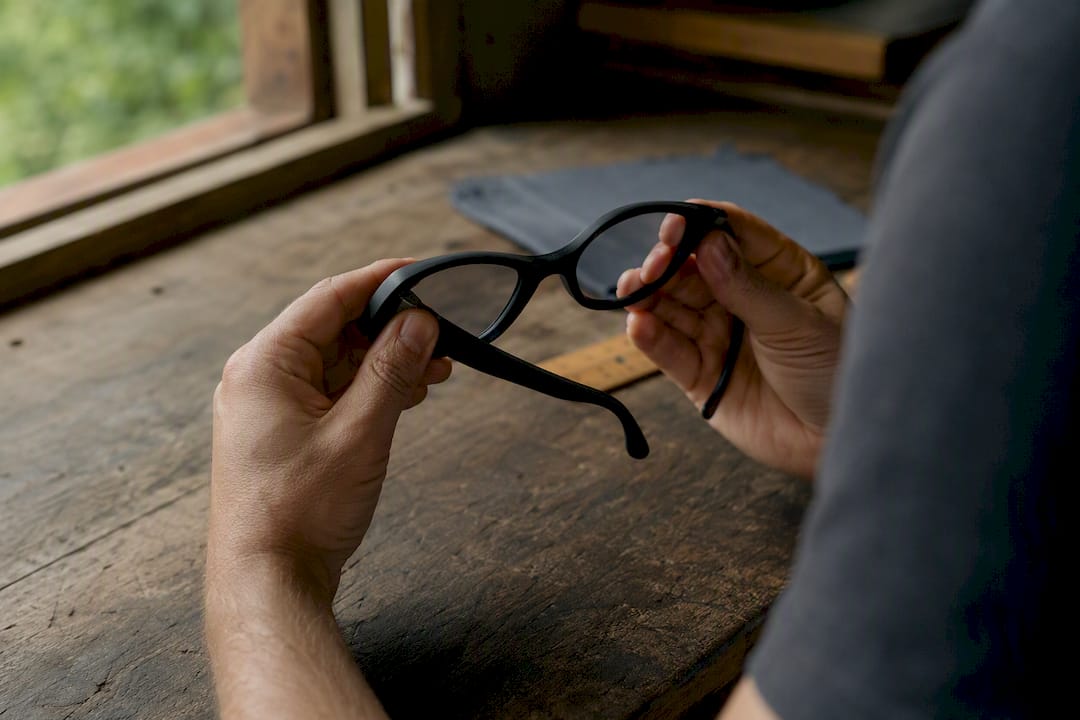 Hands flexing recycled sunglasses frame to test durability