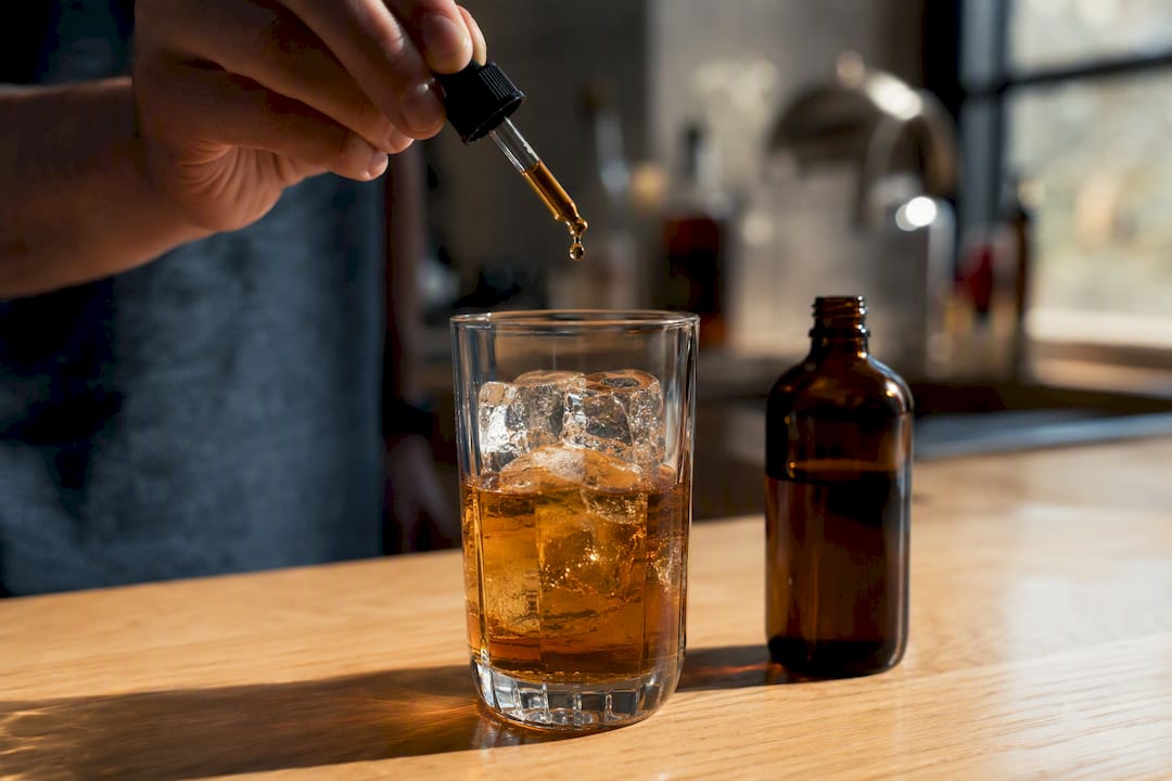Adding bitters drop to rye Old Fashioned glass