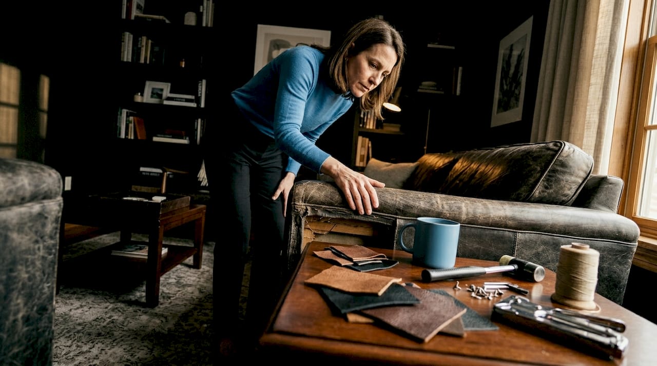 Person presses sofa arm to check frame sturdiness