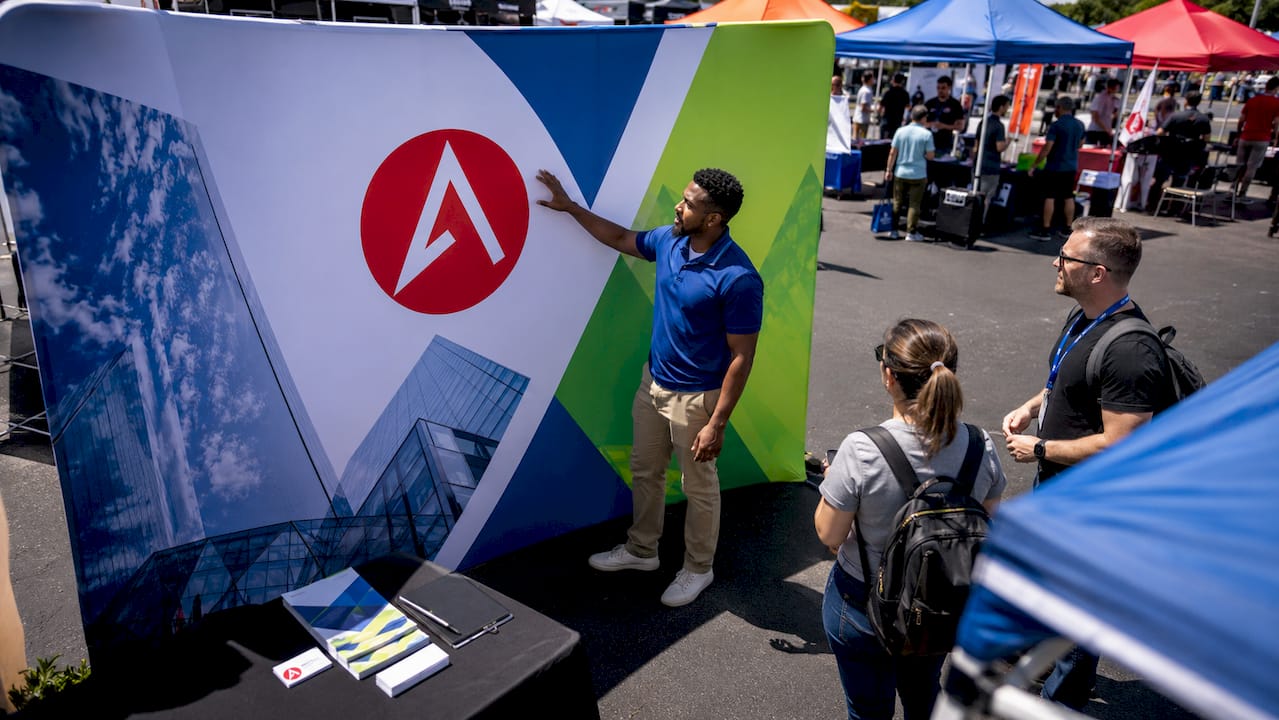 Sales rep adjusting trade show display graphics