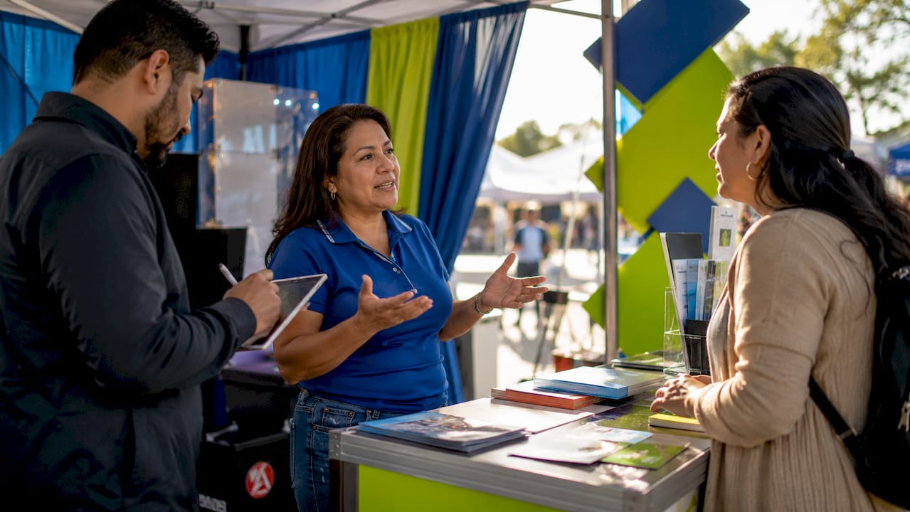 Woman engaging visitors at trade show booth