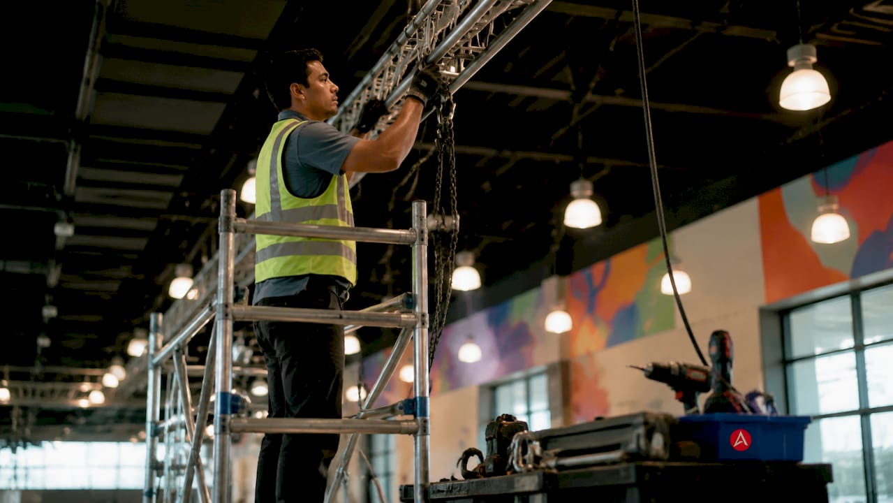 Installer attaching overhead banner at event venue