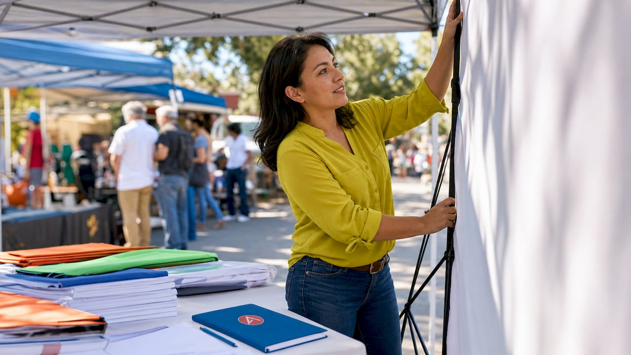 Woman setting up portable display at event booth