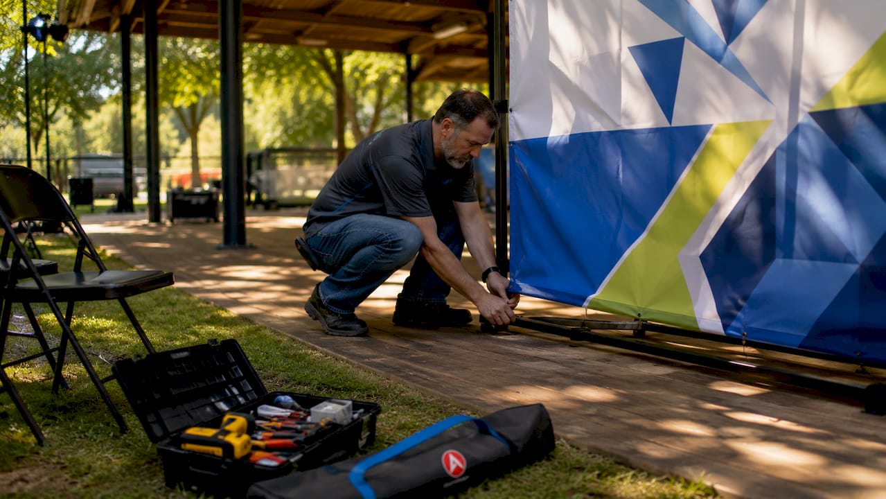 Exhibitor setting up step-and-repeat backdrop