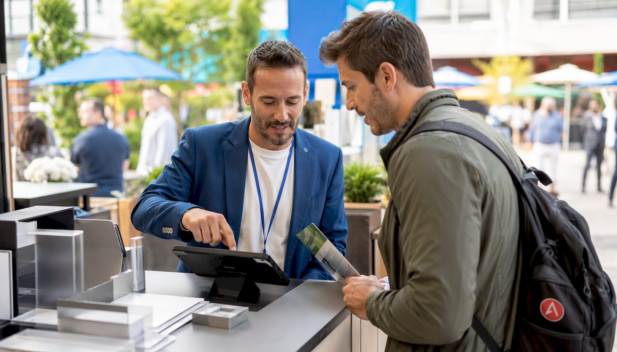Marketer engaging visitors at demo counter