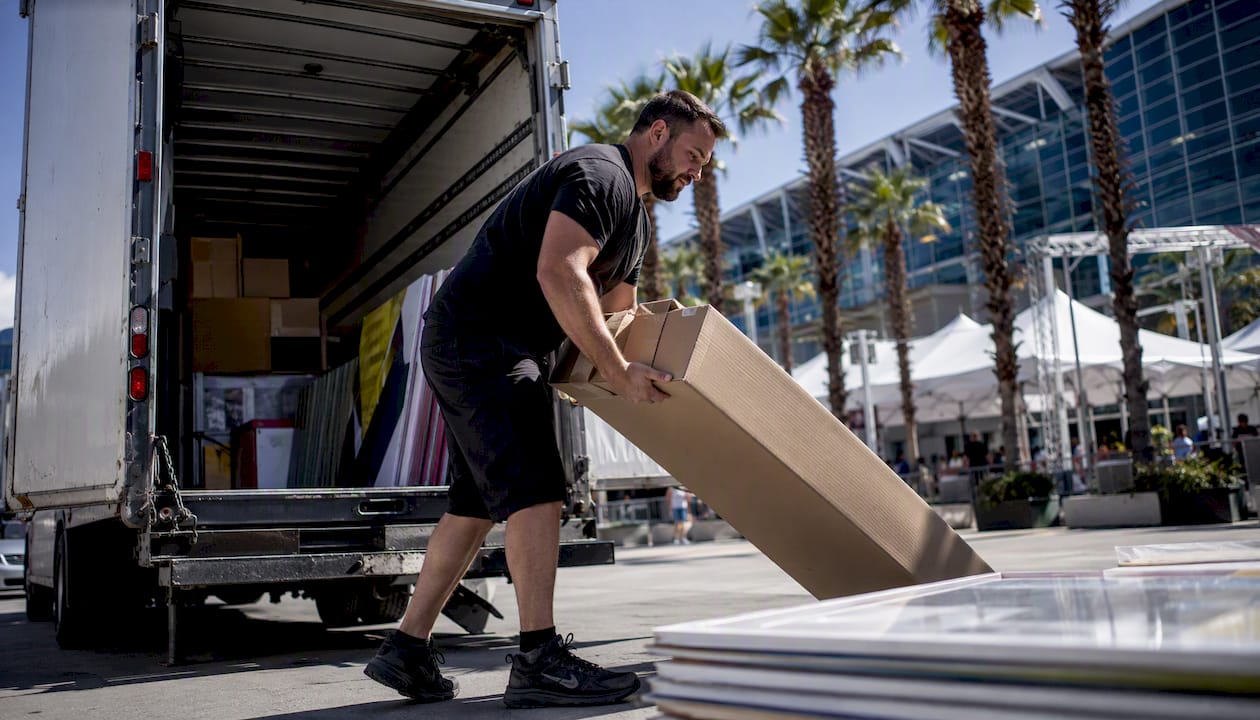Driver unloading signage from delivery van