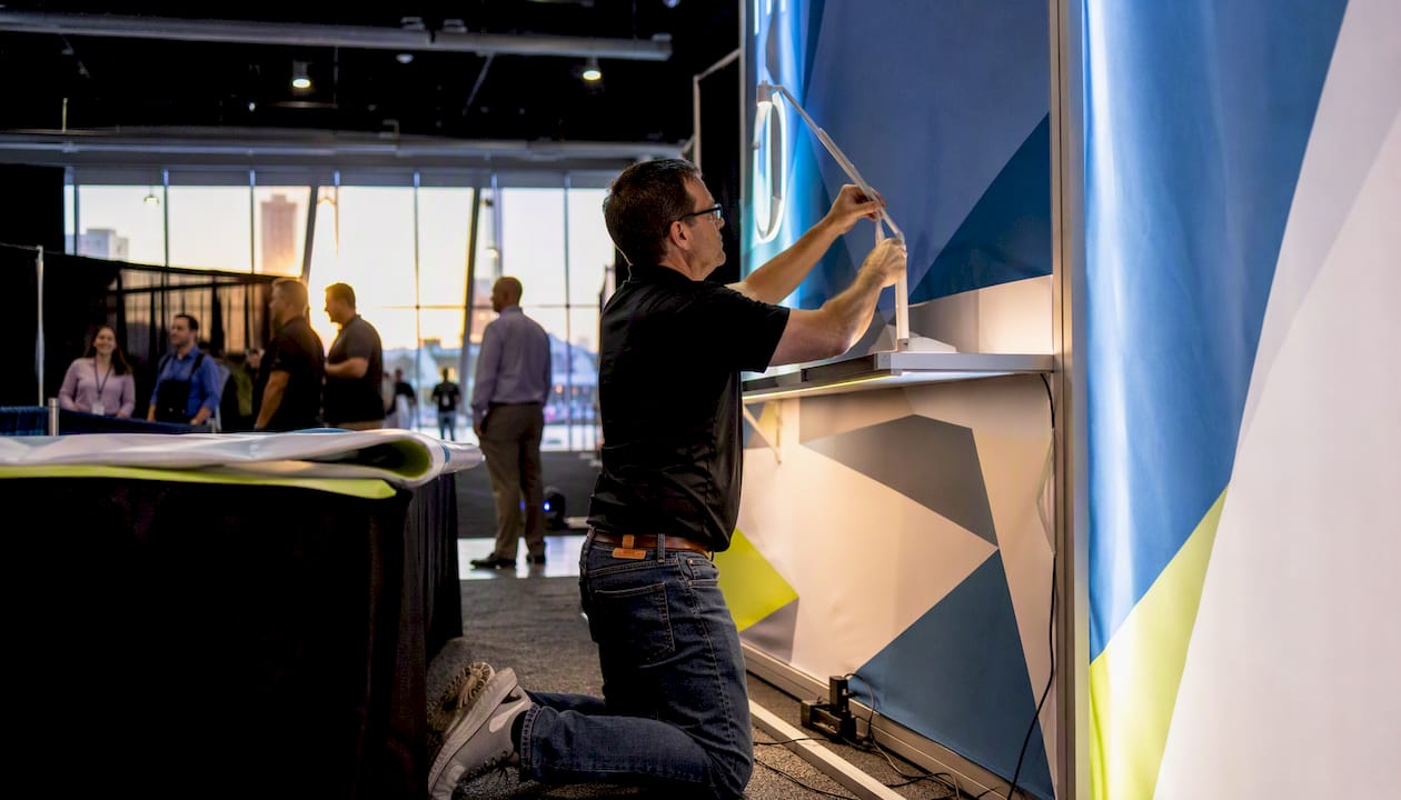 Person adjusting LED arm light in trade show booth