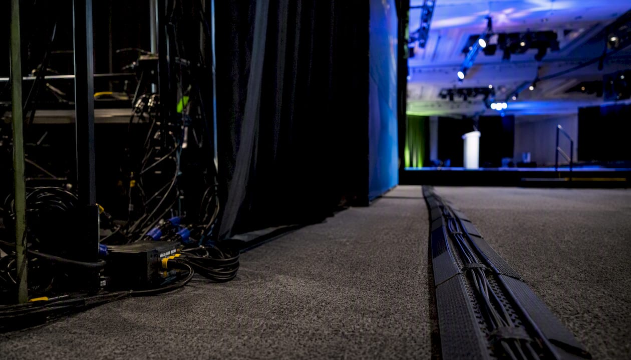 Backstage event area with cables and equipment behind backdrop