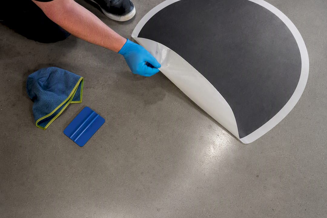 Installer peeling removable floor decal