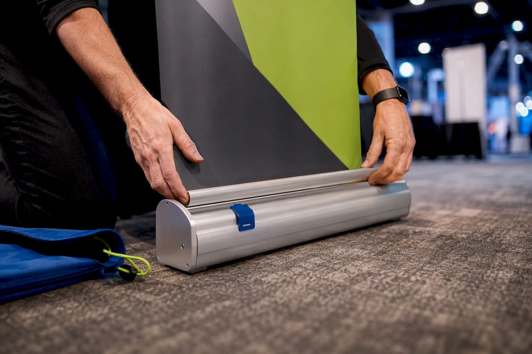 Hands setting up retractable banner hardware