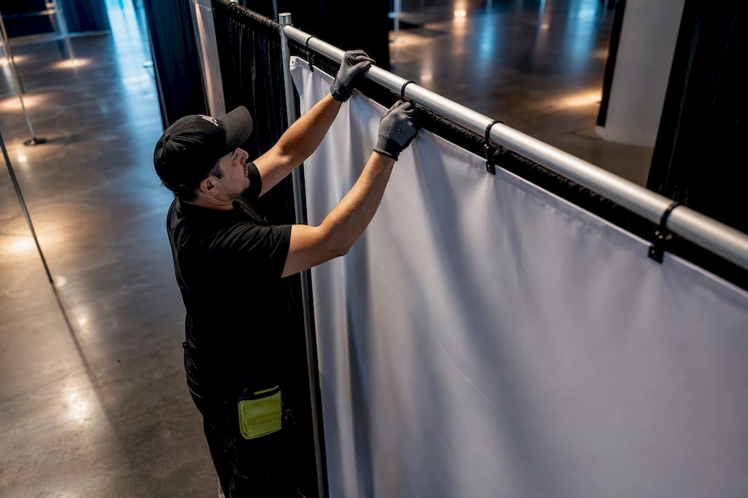Technician attaching banner to convention drape