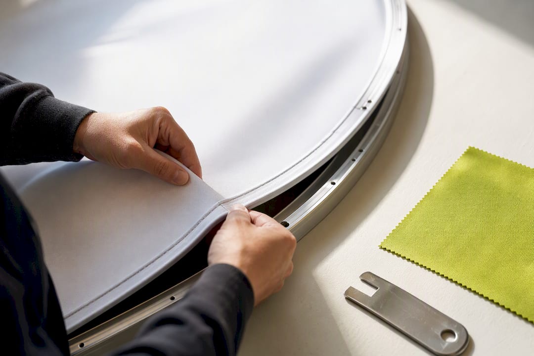 Hands aligning curved fabric panel edge