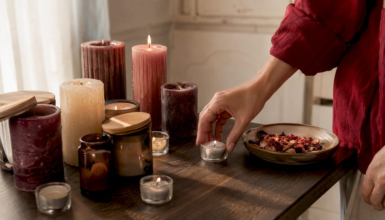 Candele profumate e decorative disposte su un tavolo in legno