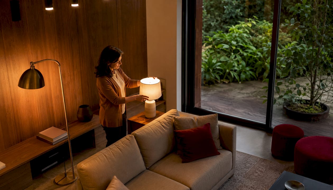 Una donna regola le luci decorative nella sua stanza, creando l’atmosfera perfetta.