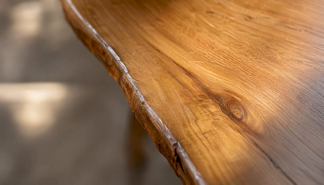 Dettaglio ravvicinato della venatura del legno di rovere lungo il bordo di un mobile.