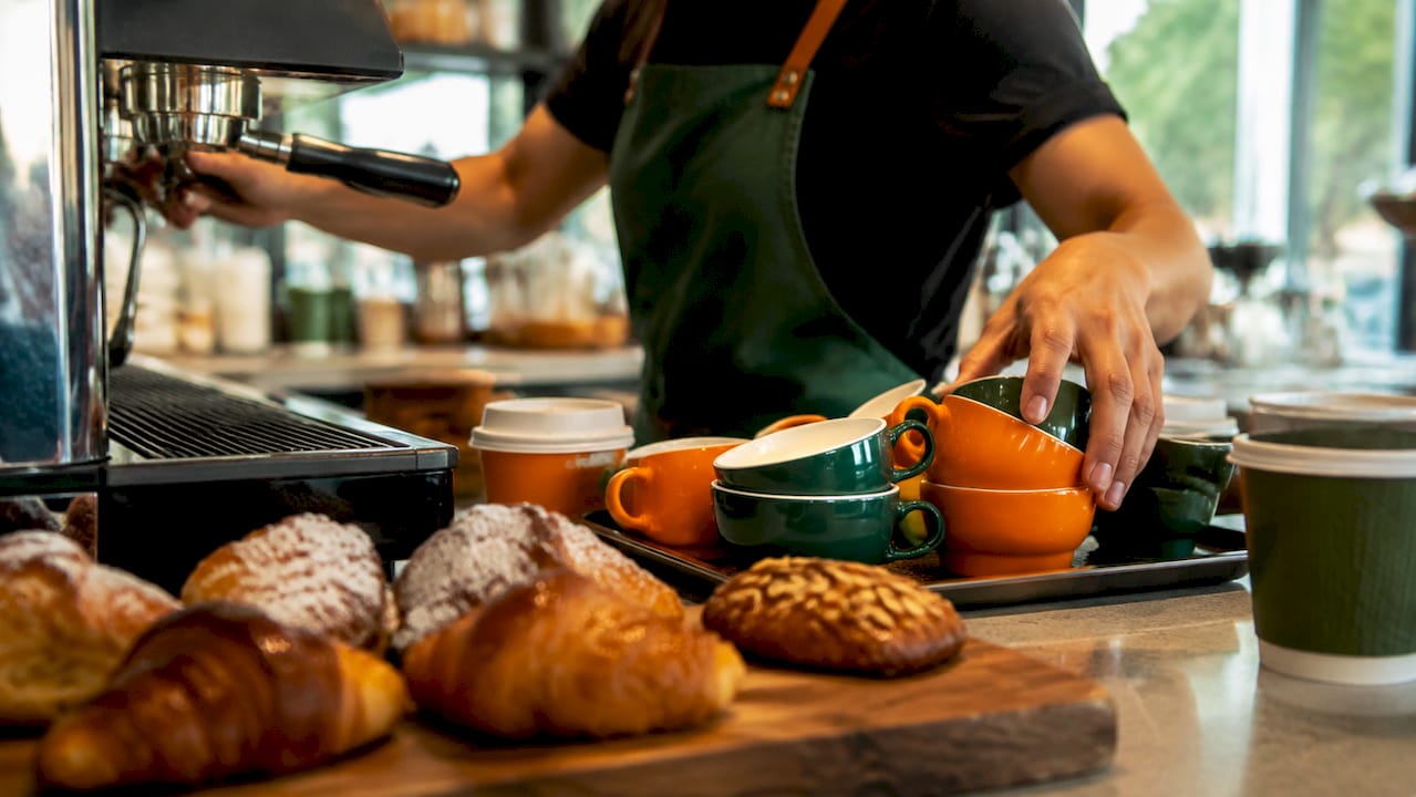 Close-up of barista’s hands multitasking coffee tasks