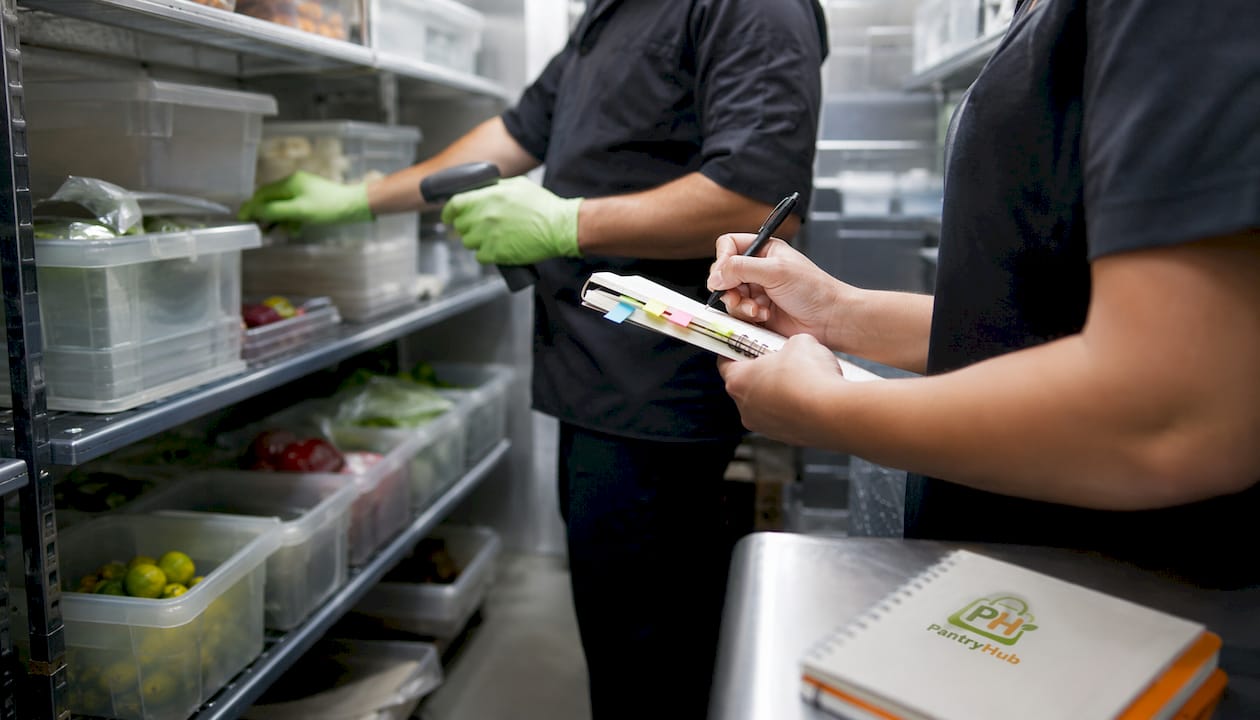 Hands counting and documenting inventory in cooler