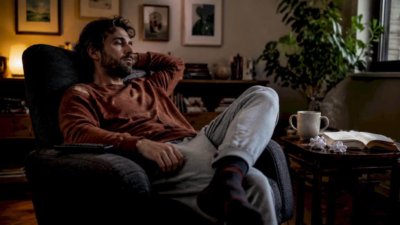 Man sitting inactive on couch in living room