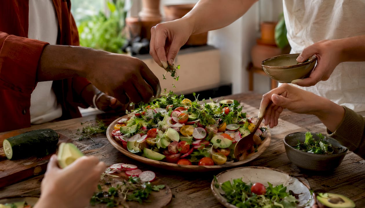 Hands preparing diverse plant foods for gut health