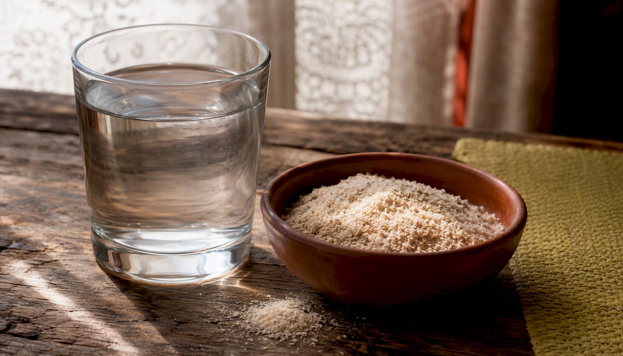 Glass of water and fiber powder on table