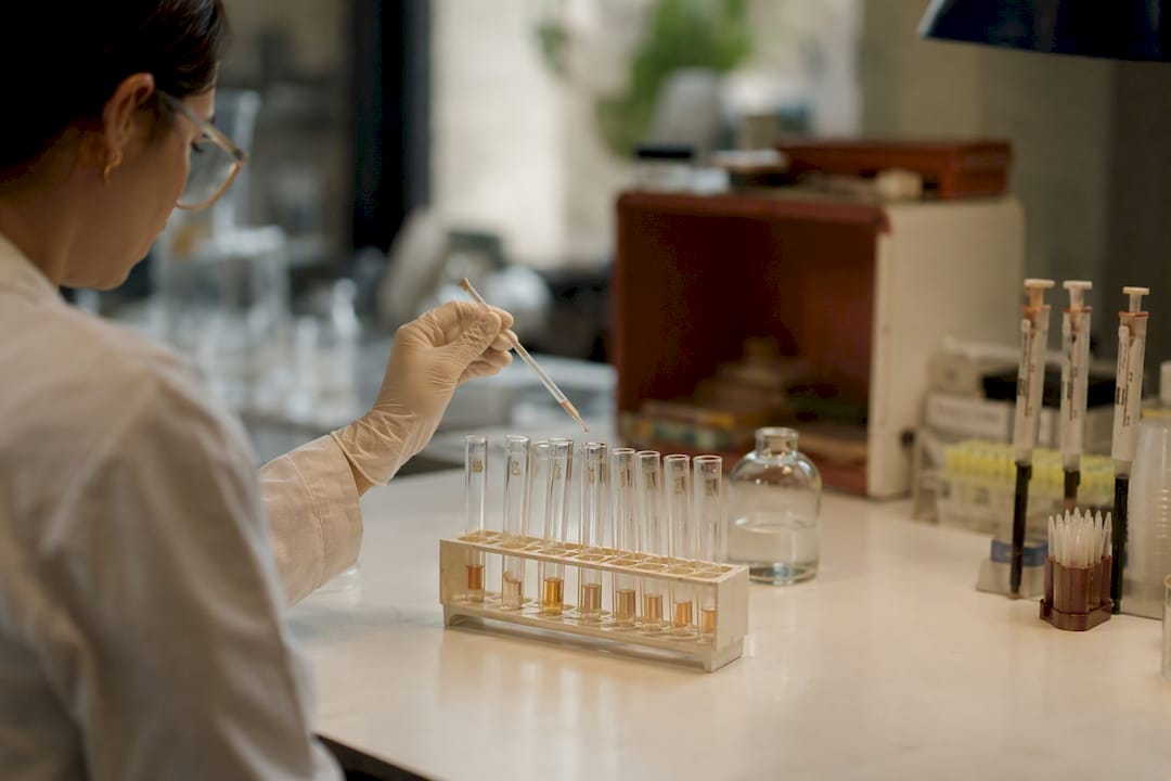 Gloved hand pipetting samples in lab