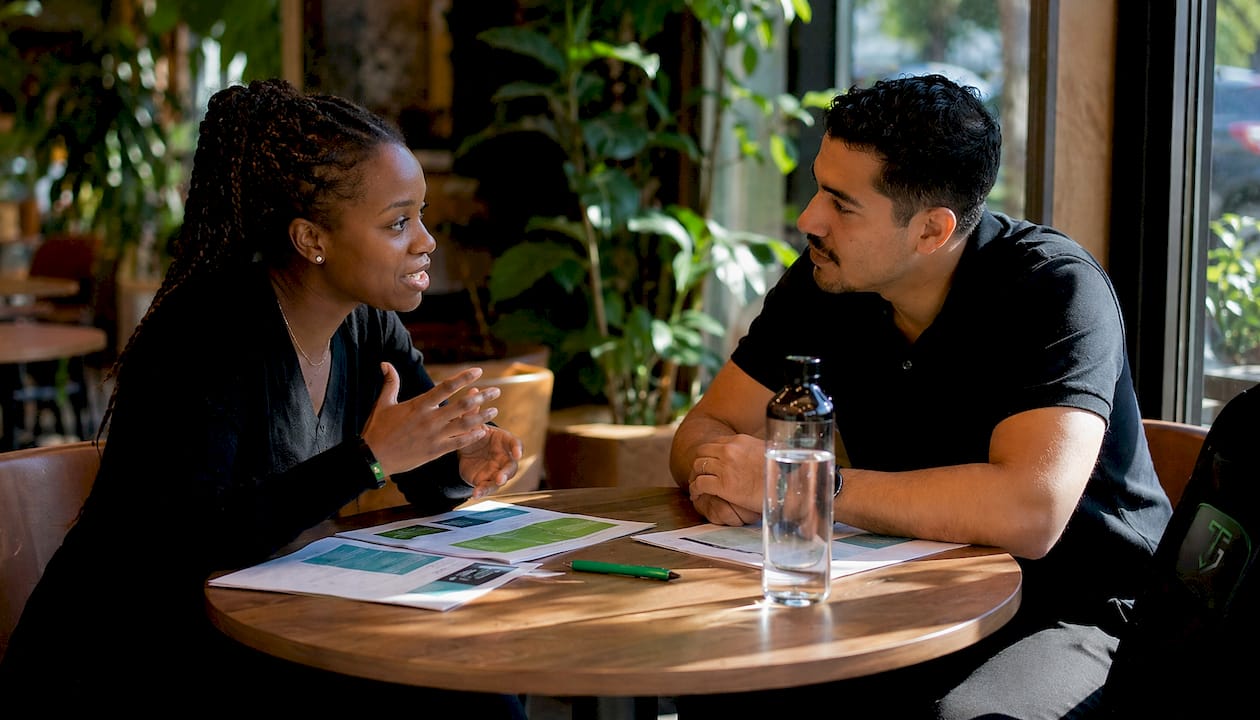 Two traders discussing application at co-working space