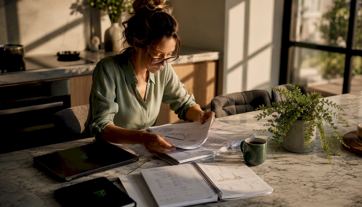 Trader reviewing trade journal at desk