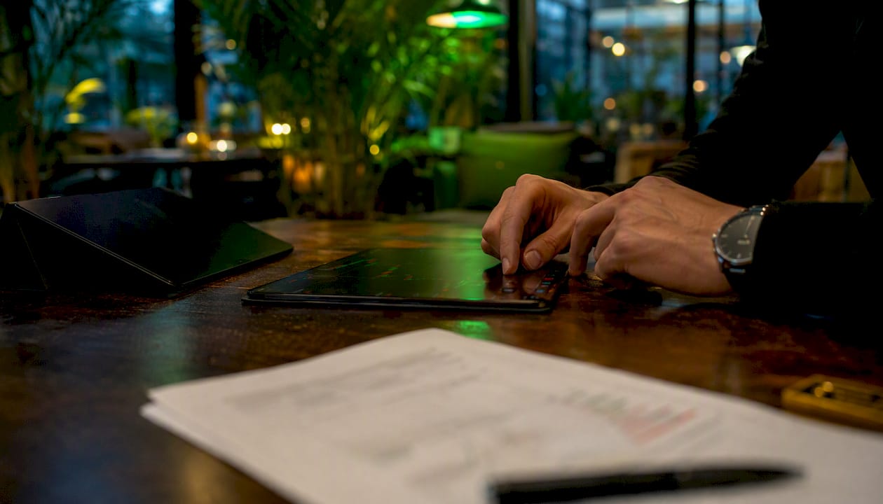 Trader's hands adjusting gold trading indicators on desk