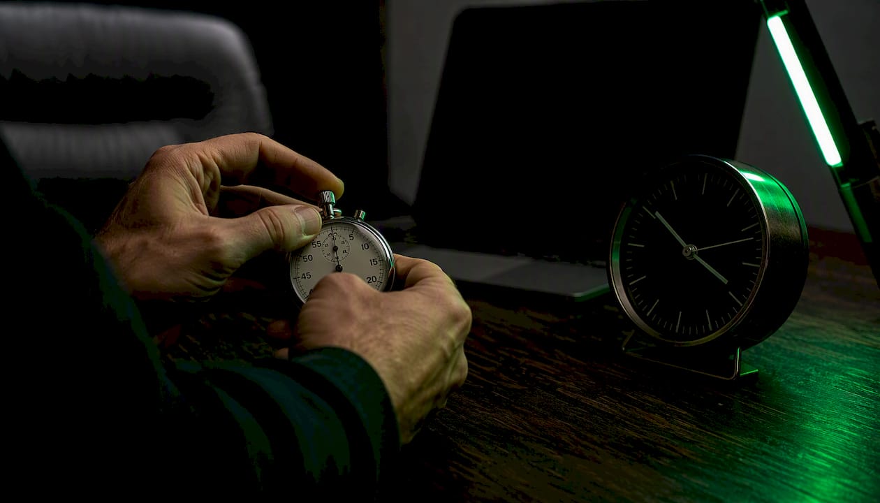 Trader timing session overlaps with stopwatch and clock