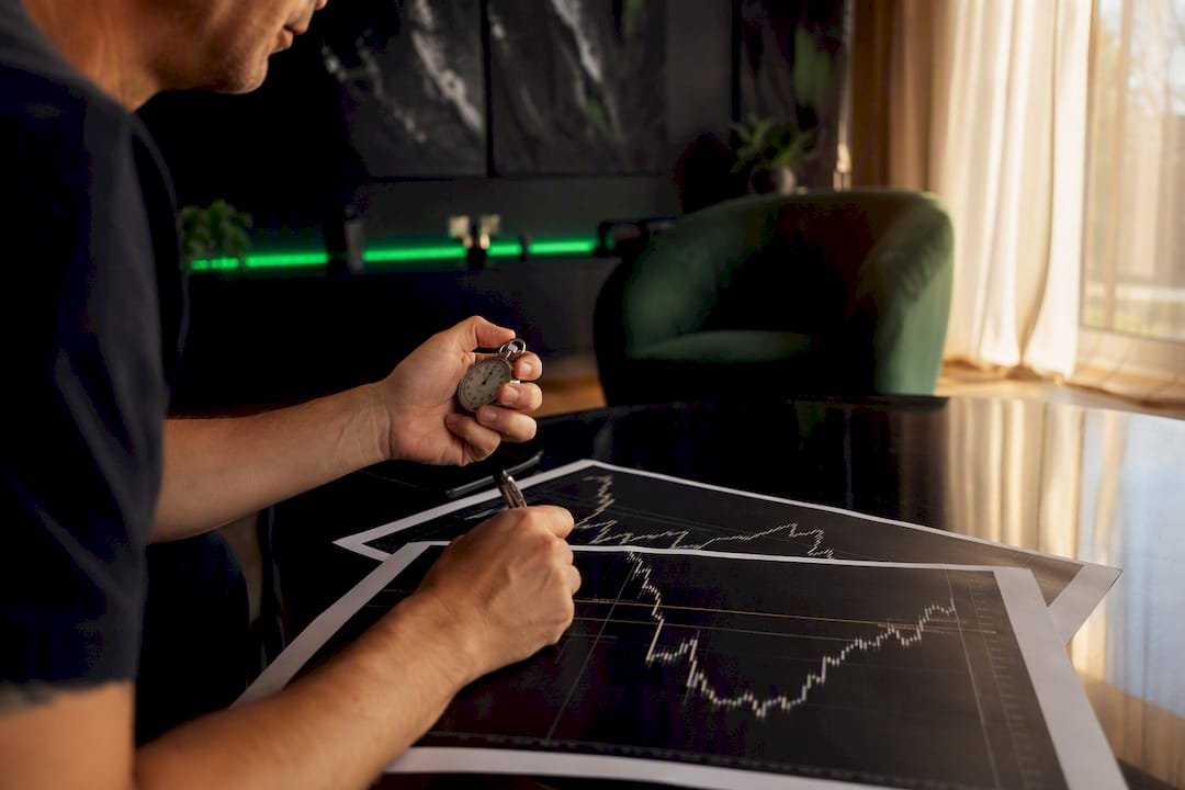 Hands marking forex chart with stopwatch