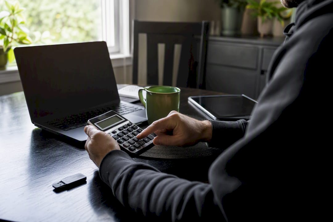 Hands using calculator for crypto tax