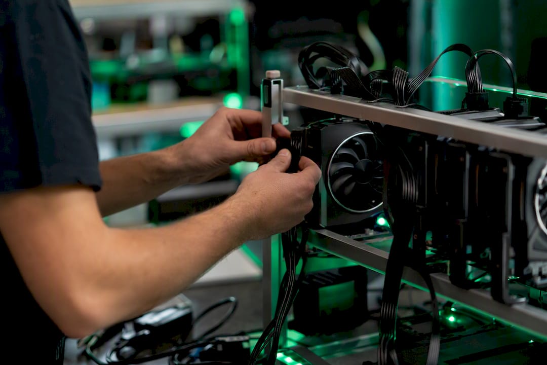 Hands connecting crypto mining hardware power cable