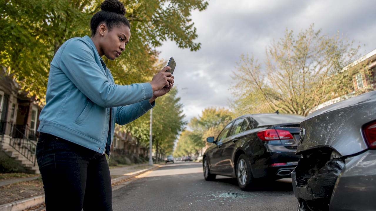 Person photographing car accident details
