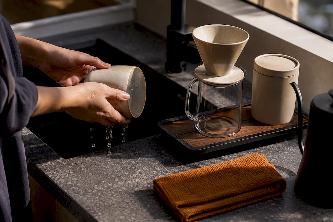 Hands resetting a tidy coffee station
