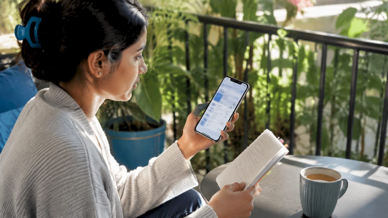 Hands using telehealth scheduling app on smartphone