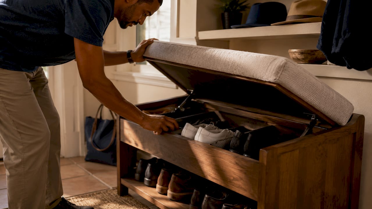 Man accessing storage inside entryway bench