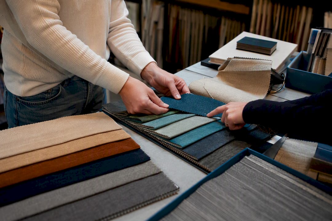 Hands comparing fabric swatches in showroom