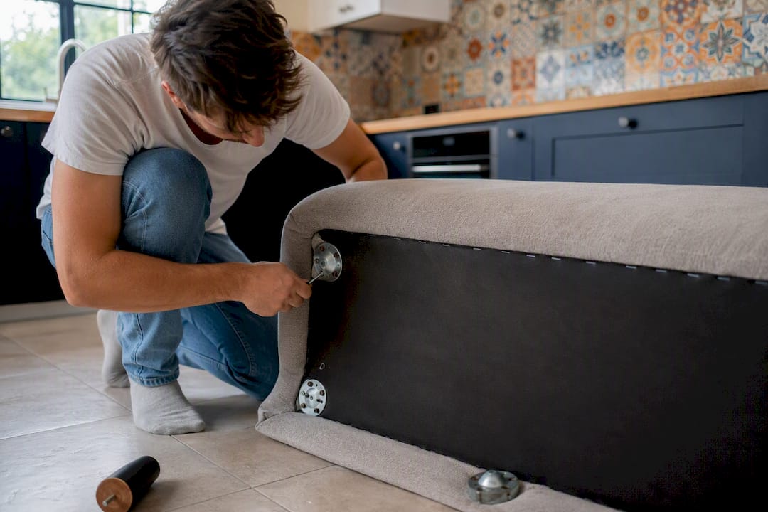 Hands removing sofa cushions and legs